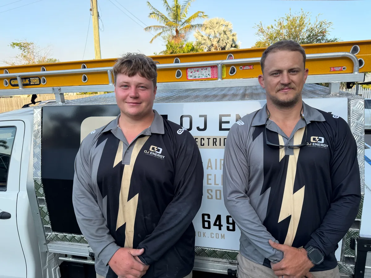 Two OJ Energy team members standing in front of their service truck